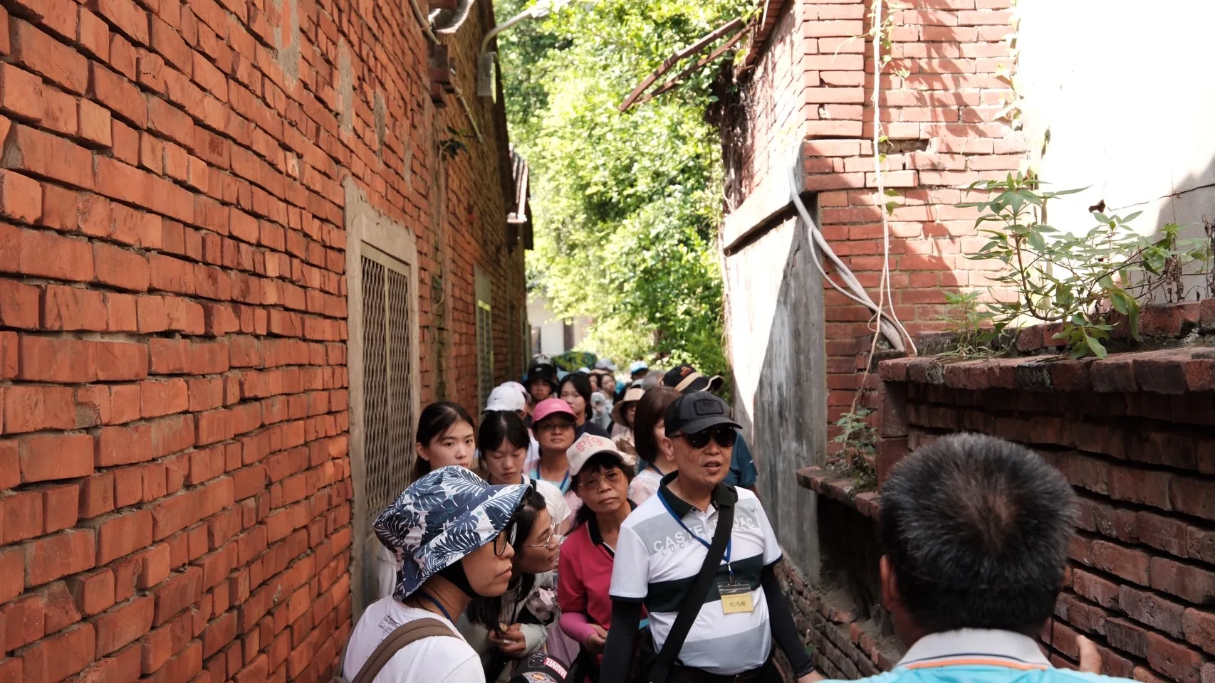 在地人凃進興導覽員帶領民眾穿梭於海墘巷弄中講述建築歷史。台中市政府客委會提供