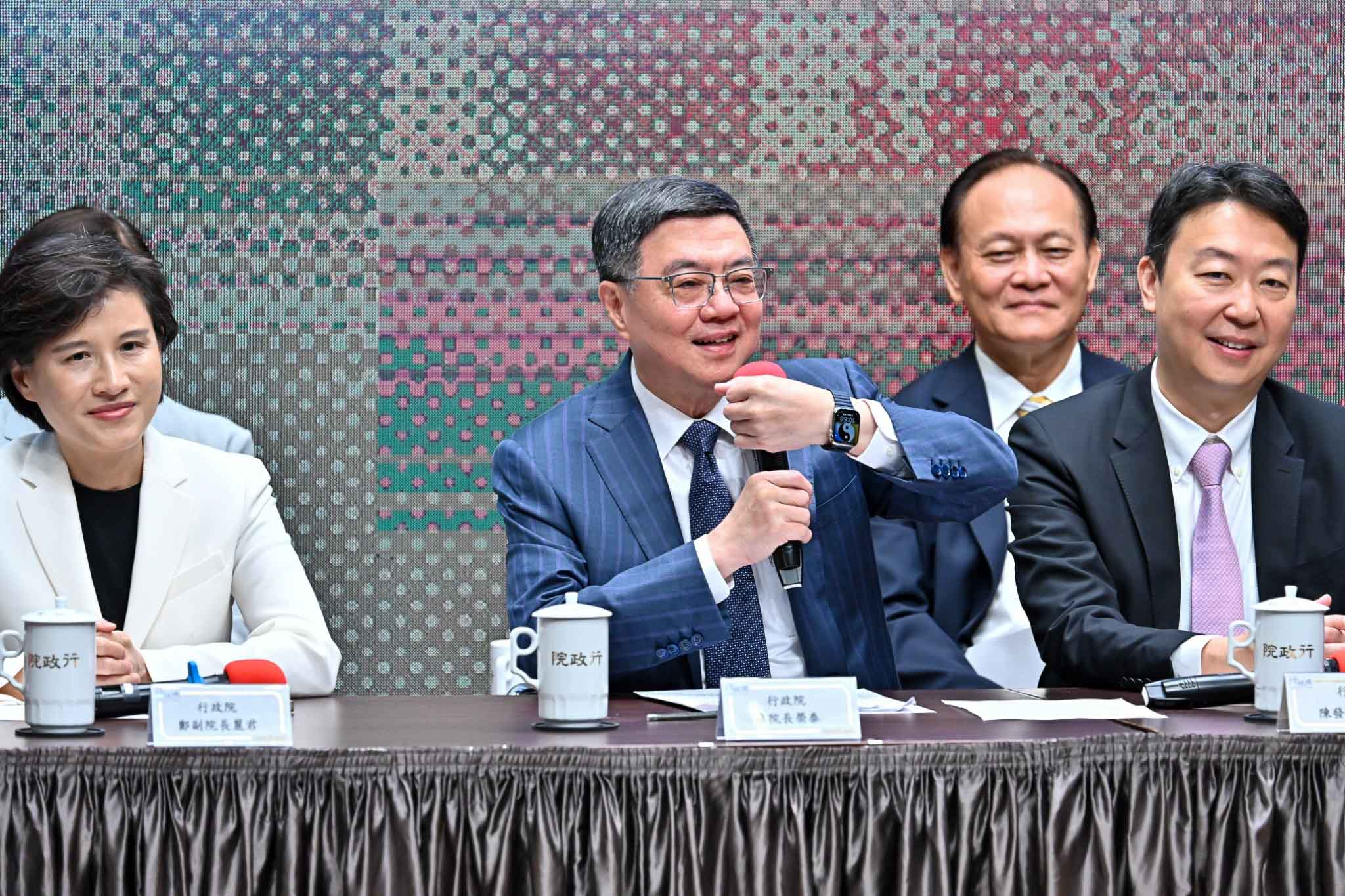 卓榮泰在記者會上秀出手錶上的太極圖案，用「太極圖」形容他與總統賴清德的互動。行政院提供