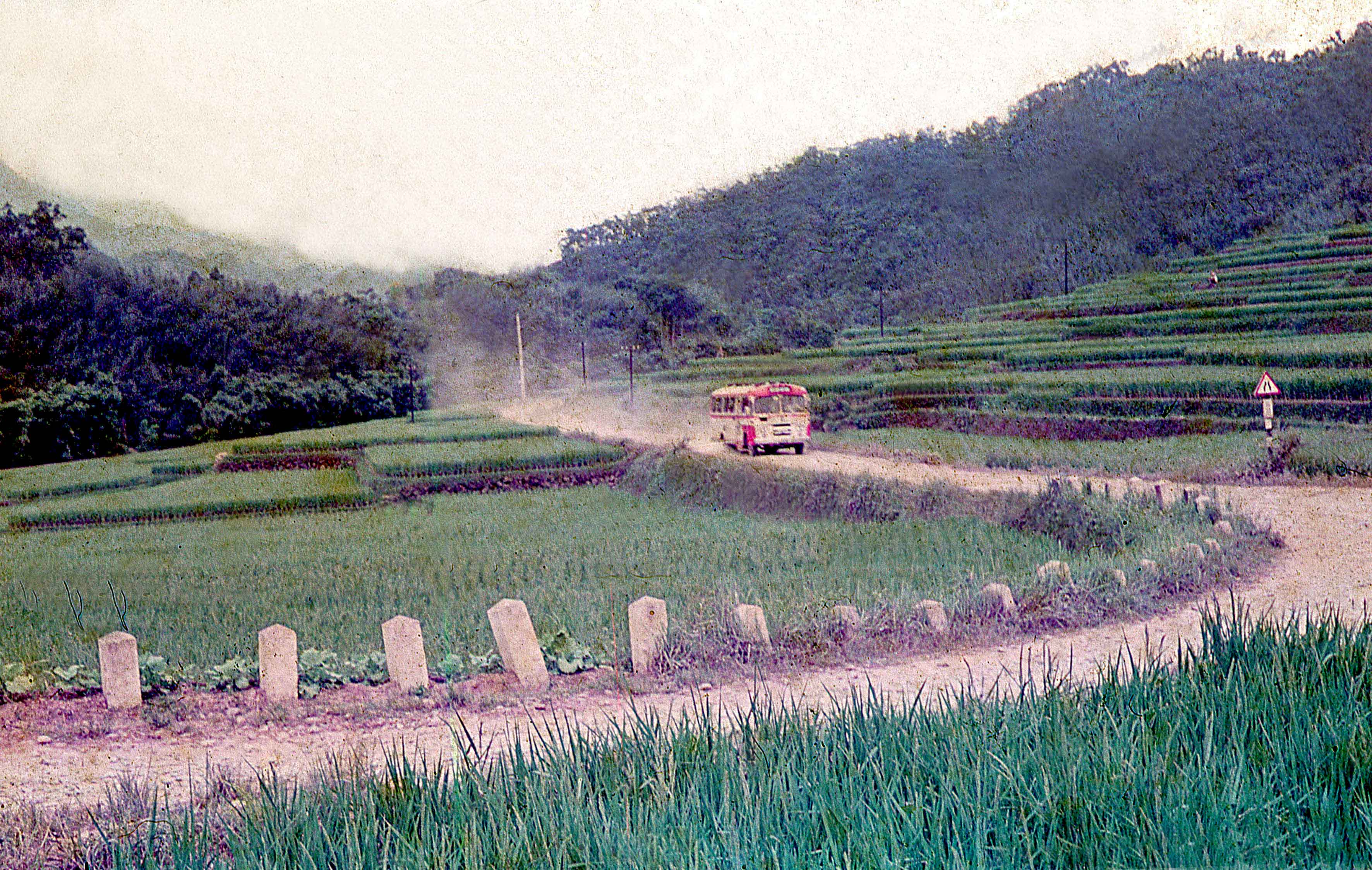 1975年一輛橘黃色新竹客運班車,行駛在臺三線獅潭桂竹林段,因路面狹窄,且未鋪柏油,車行塵土飛揚。陳錦雲提供