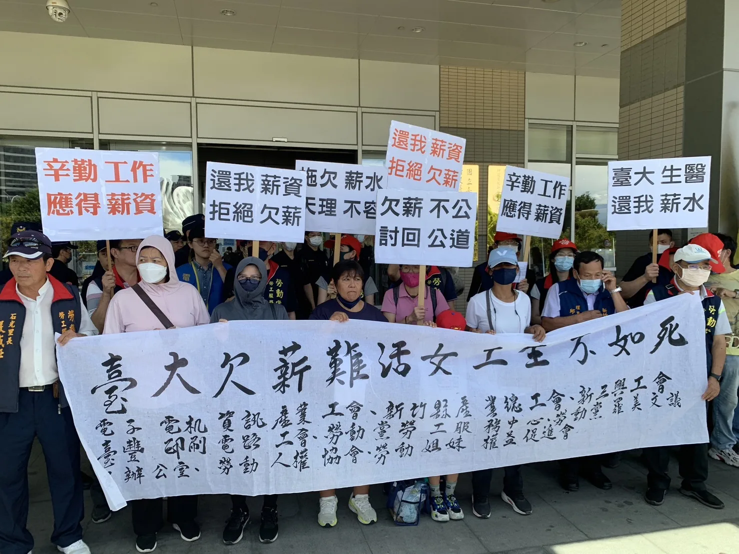 今天有清潔工到臺大醫院新竹生醫園區分院拉白布條抗議。羅盛滿攝影