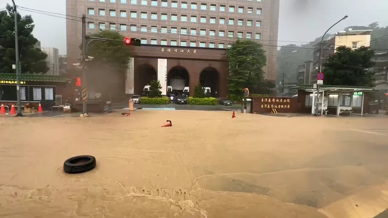 大雨狂炸基隆市,基隆地方法院前東信路(圖)嚴重淹水,整條馬路頓時成河道。中央社