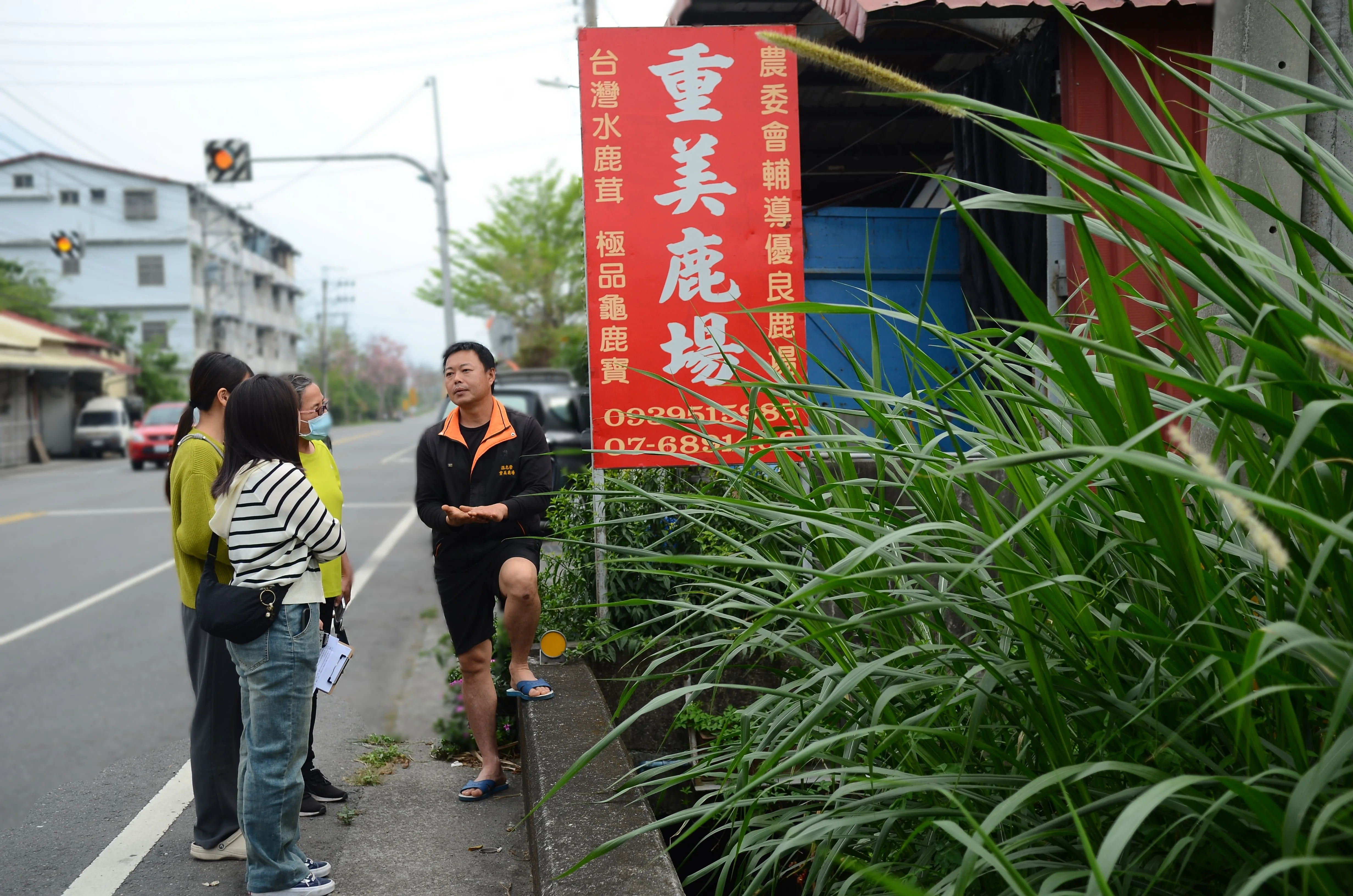 文武里養鹿場老闆溫志崇(右)與社大團隊介紹牧草及鹿場。旗美社大提供
