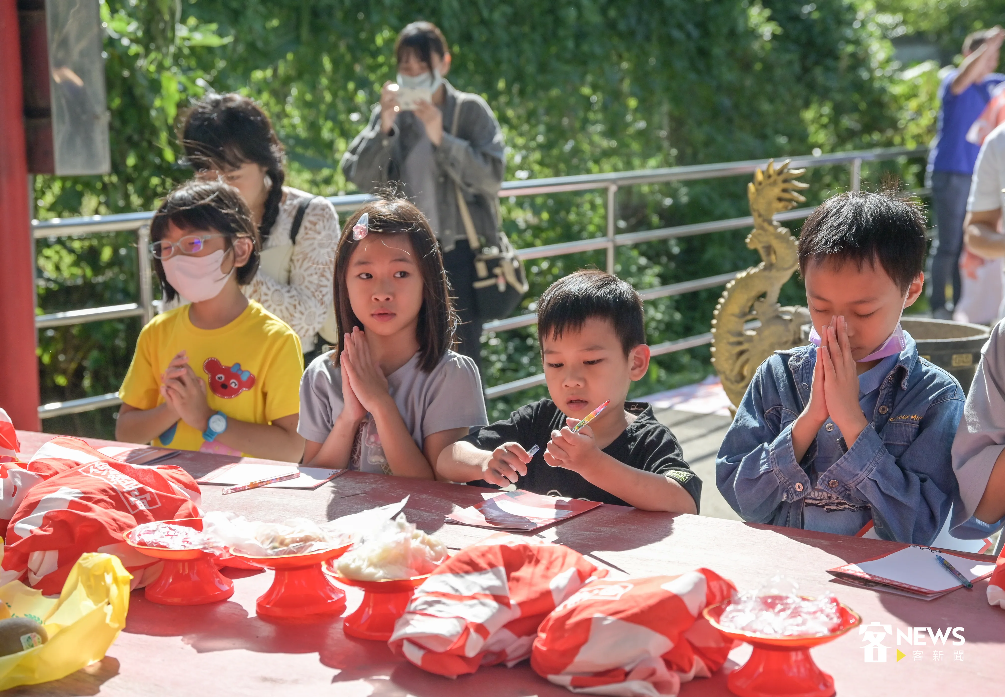 小朋友將粄食擺放在供桌,虔誠向第一站水頭伯公敬拜。洪俊傑攝
