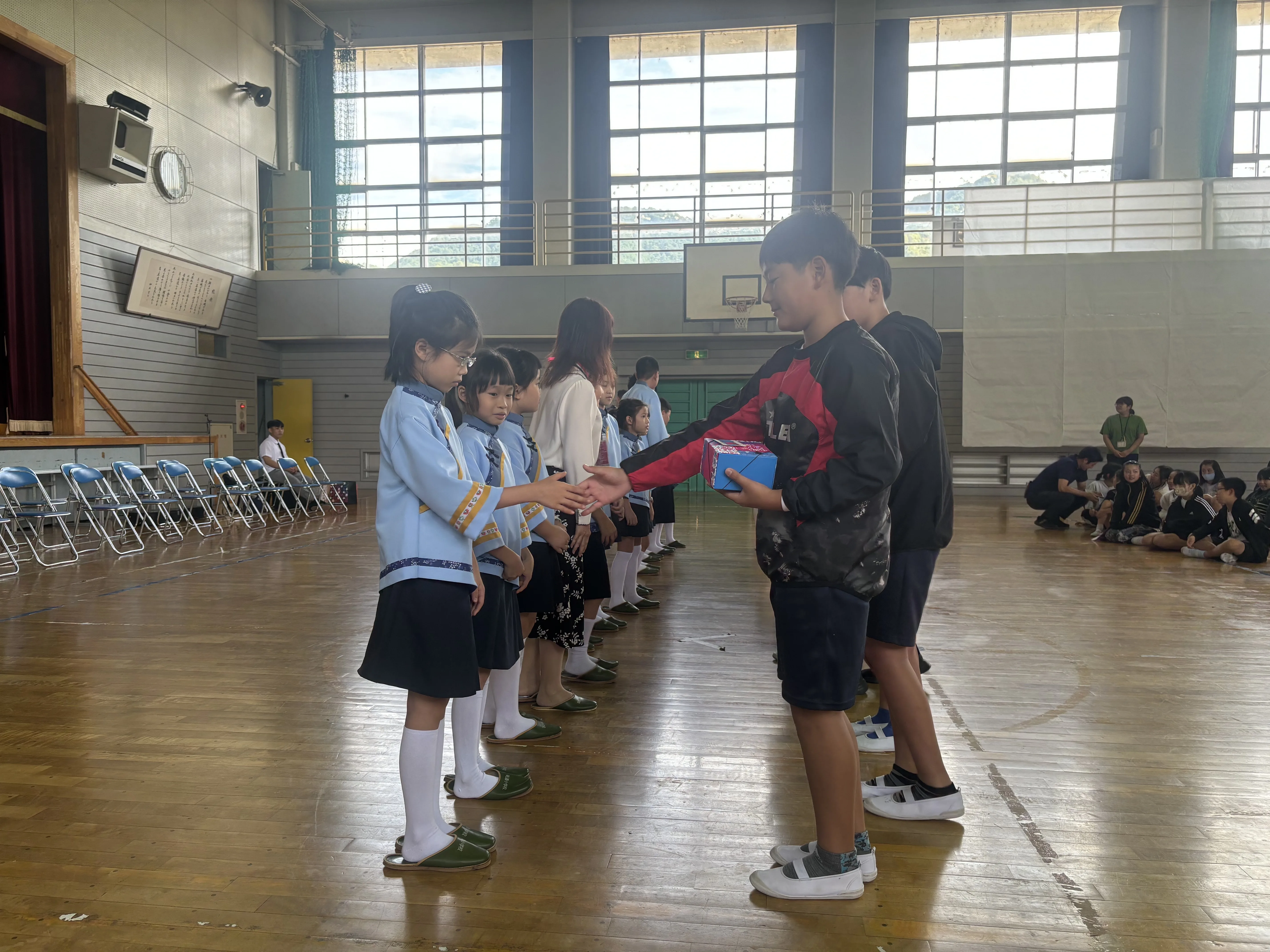 高雄市兒童合唱團昨上午到日本美濃小學校交流演唱，並互贈禮物。高市府客委會提供