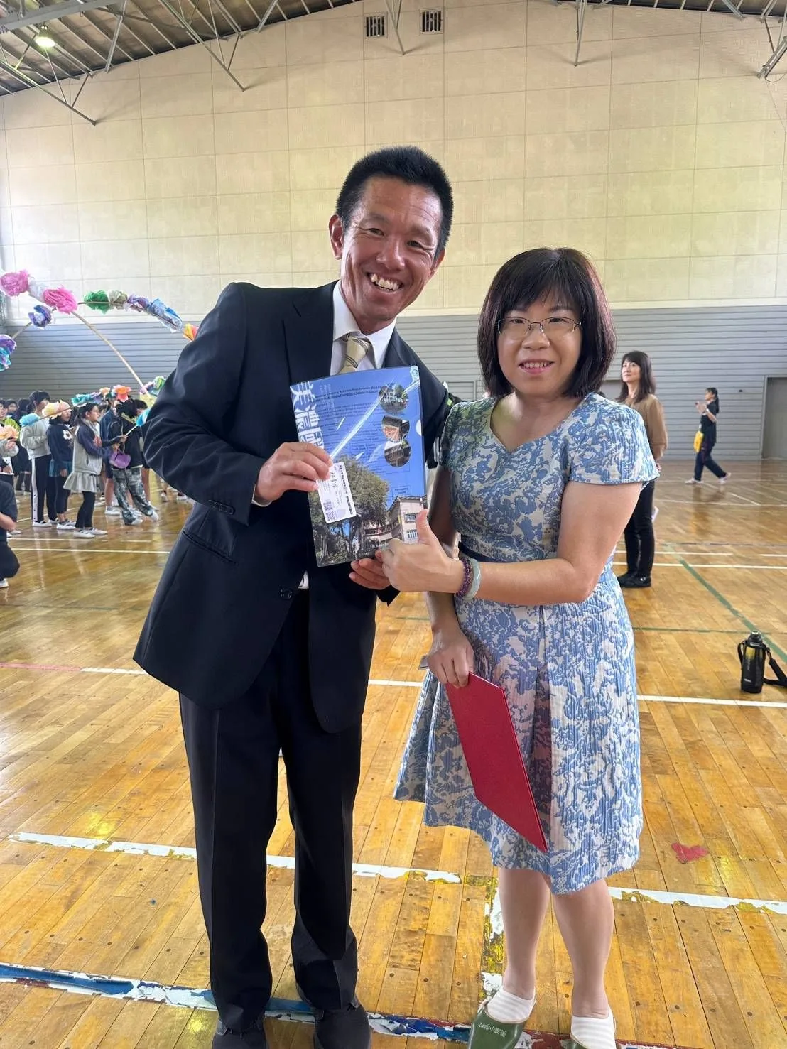 美濃國小校長邱彥瑄致贈校刊給日本美濃小學校。高市府客委會提供