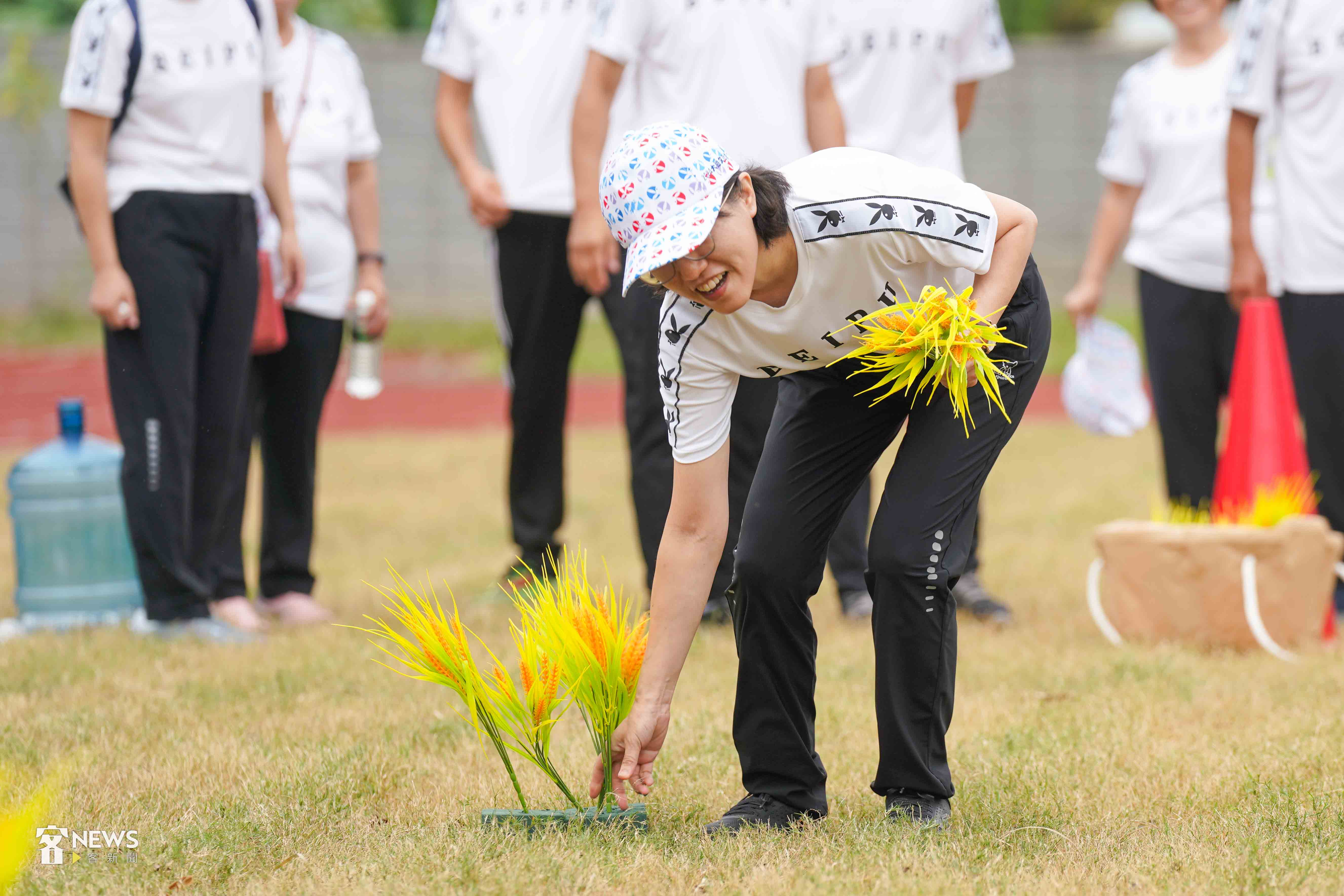 「插秧比賽」由參賽者依序將秧苗插入地上指定道具。李台源攝