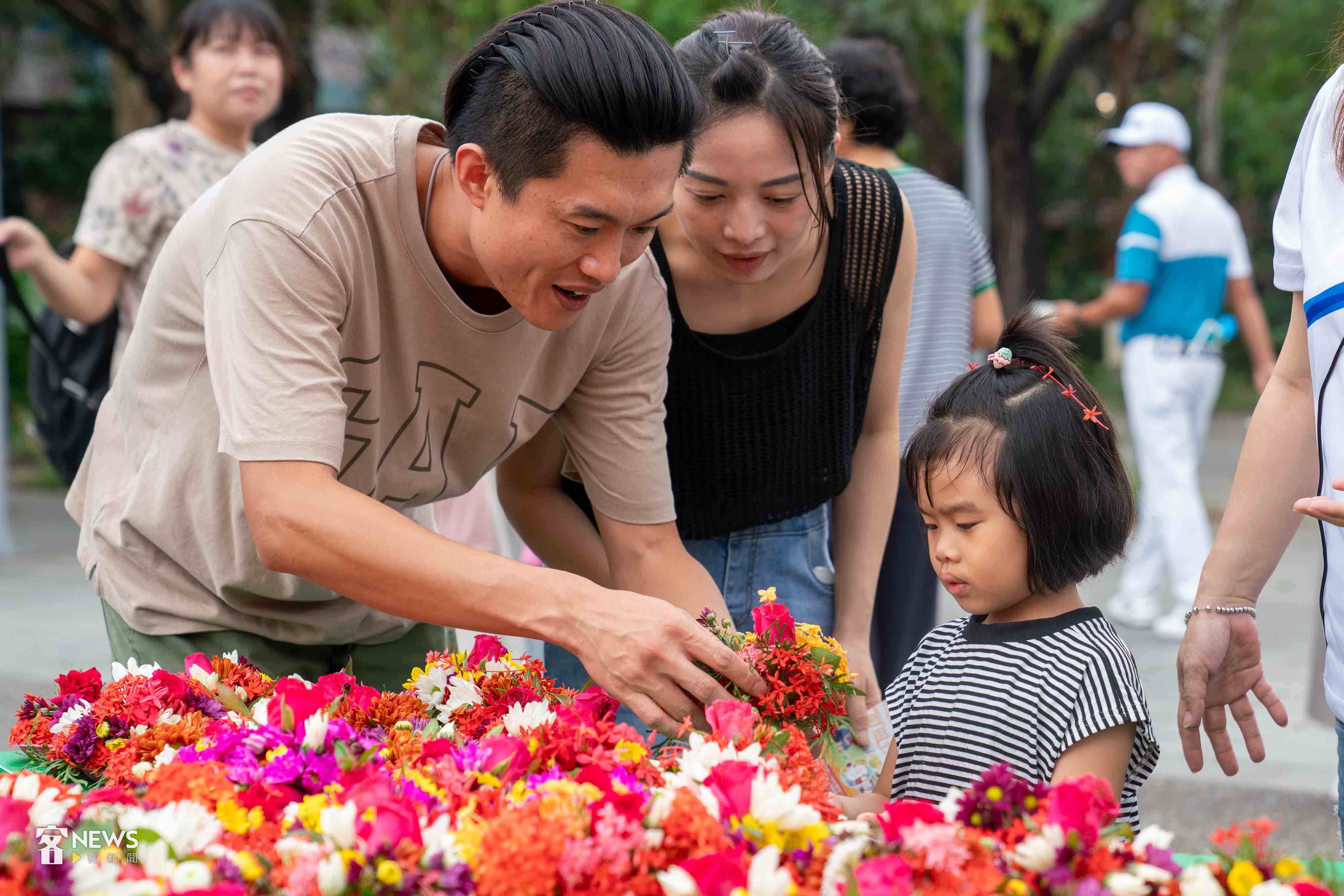 家長帶著小朋友用盤花向伯公祈福。李台源攝