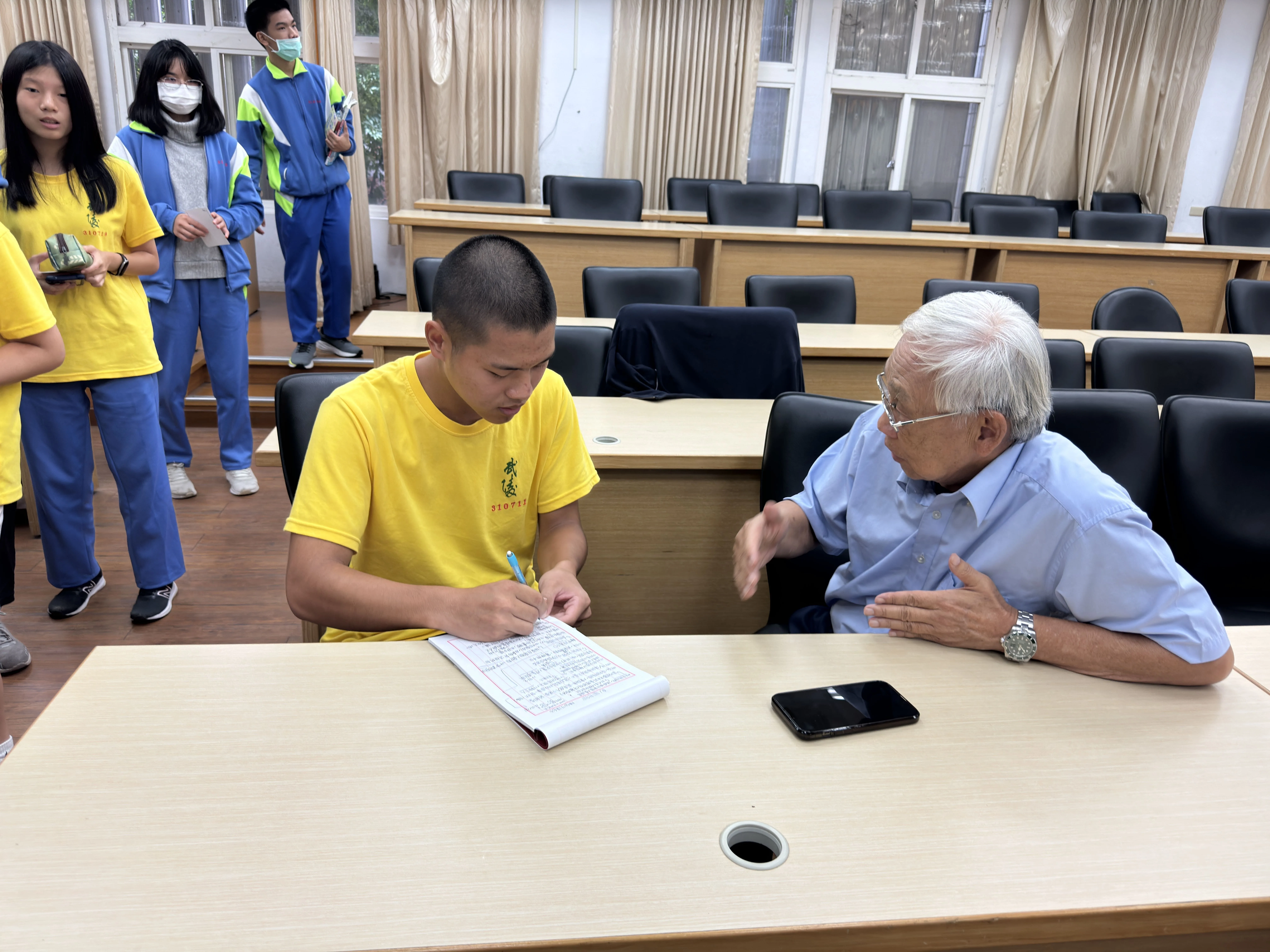 活動結束後，武陵同學踴躍地排隊等候與生哥交流心得，圖中同學拿著滿滿的筆記，正與生哥熱絡地交流。國家人權博物館提供