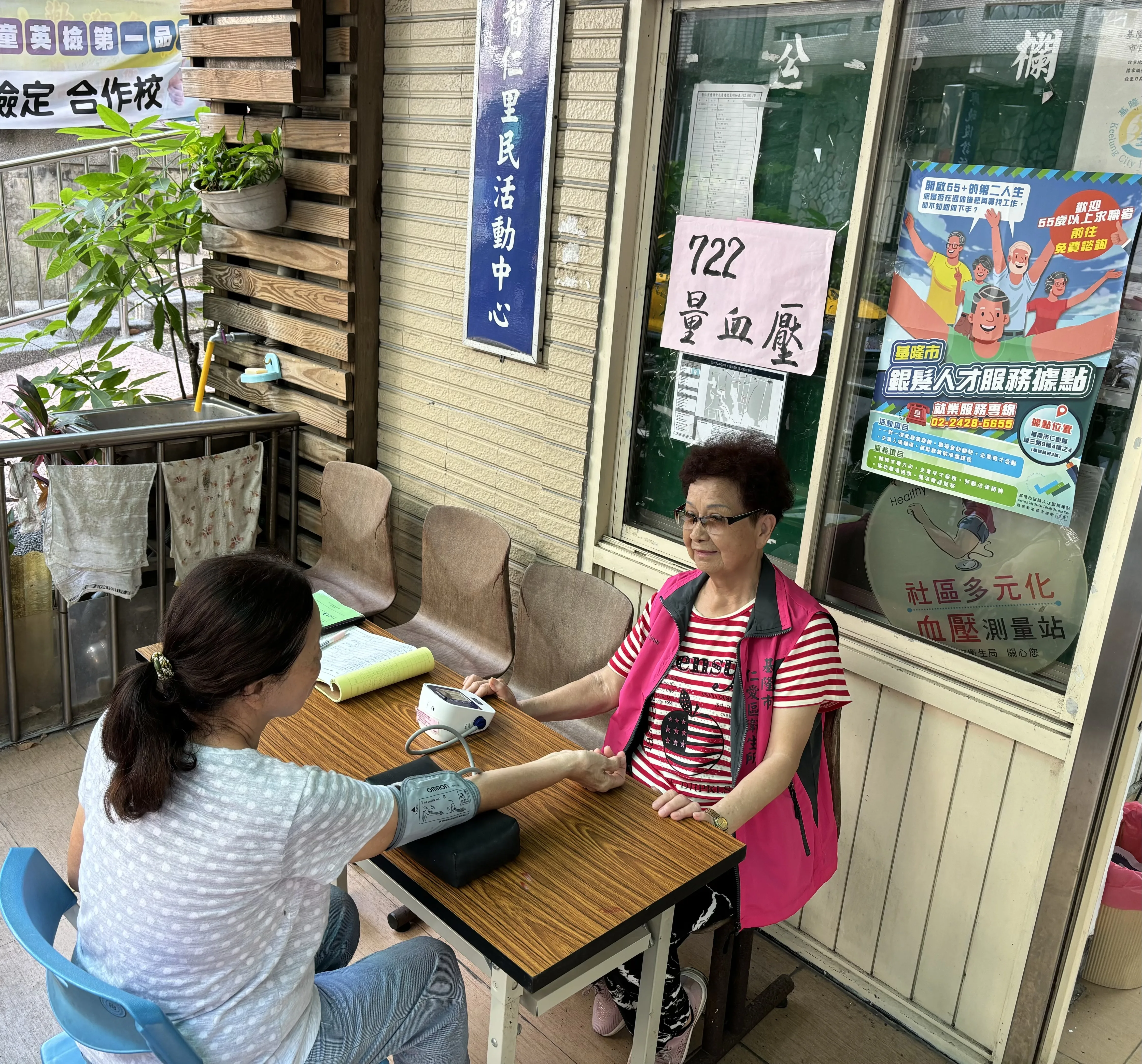 志工在里民中心，協助民眾以手臂式血壓計量測血壓。基隆市衛生局提供