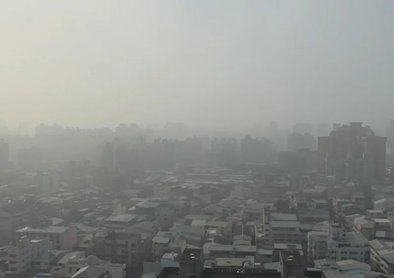 環境風場偏東風，影響台中地區近日空氣品質，圖為15日遠眺市區一片白茫茫。中央社