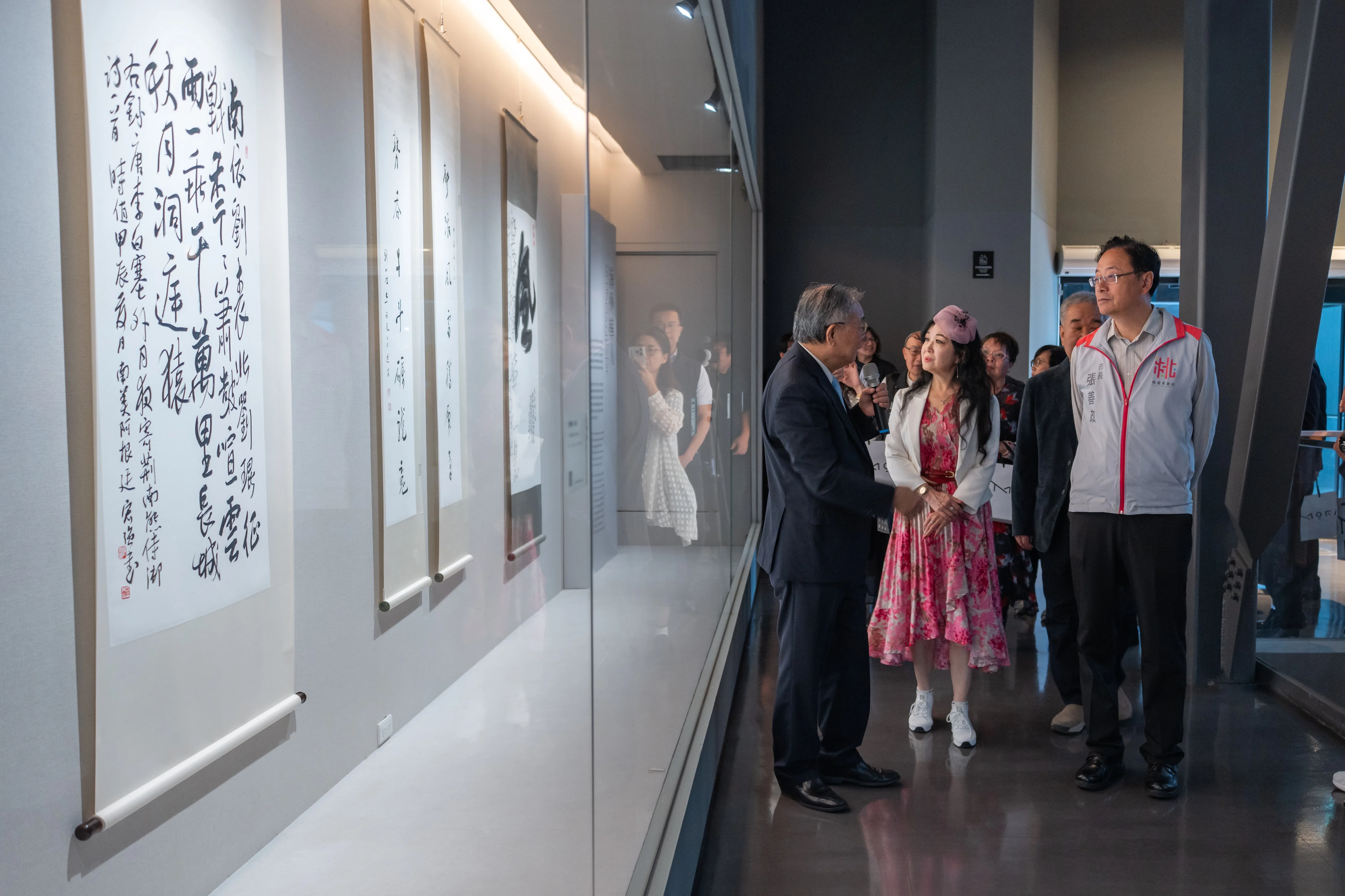 桃園市長張善政、與會貴賓，一起聆聽策展人張炳煌導覽。桃園市立美術館提供