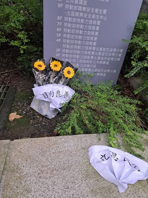 勞動部公務員輕生，勞動部「目的良善」用語引發外界不滿；有民眾獻花標注「目的良善」、「立意良善」，哀悼離世公務員。讀者提供