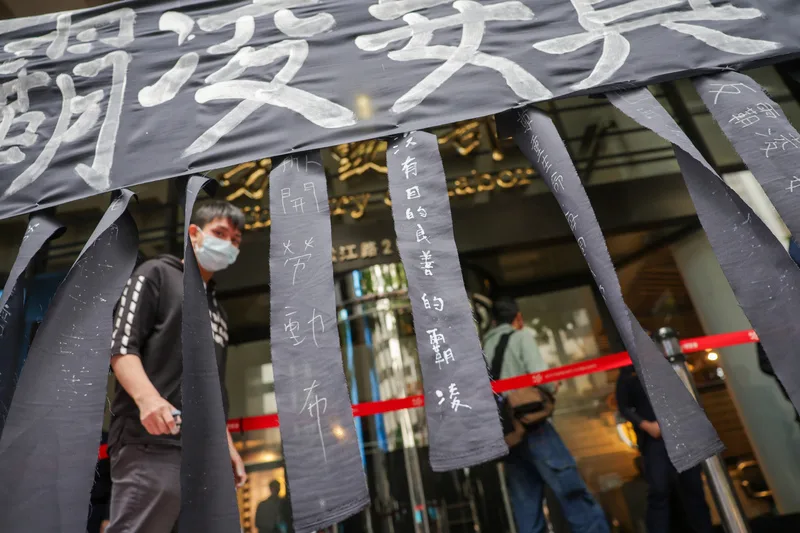 勞動部北分署公務員輕生案，時代力量黨主席王婉諭、東吳大學法律系教授胡博硯等人21日在勞動部門口掛上黑布條抗議。中央社