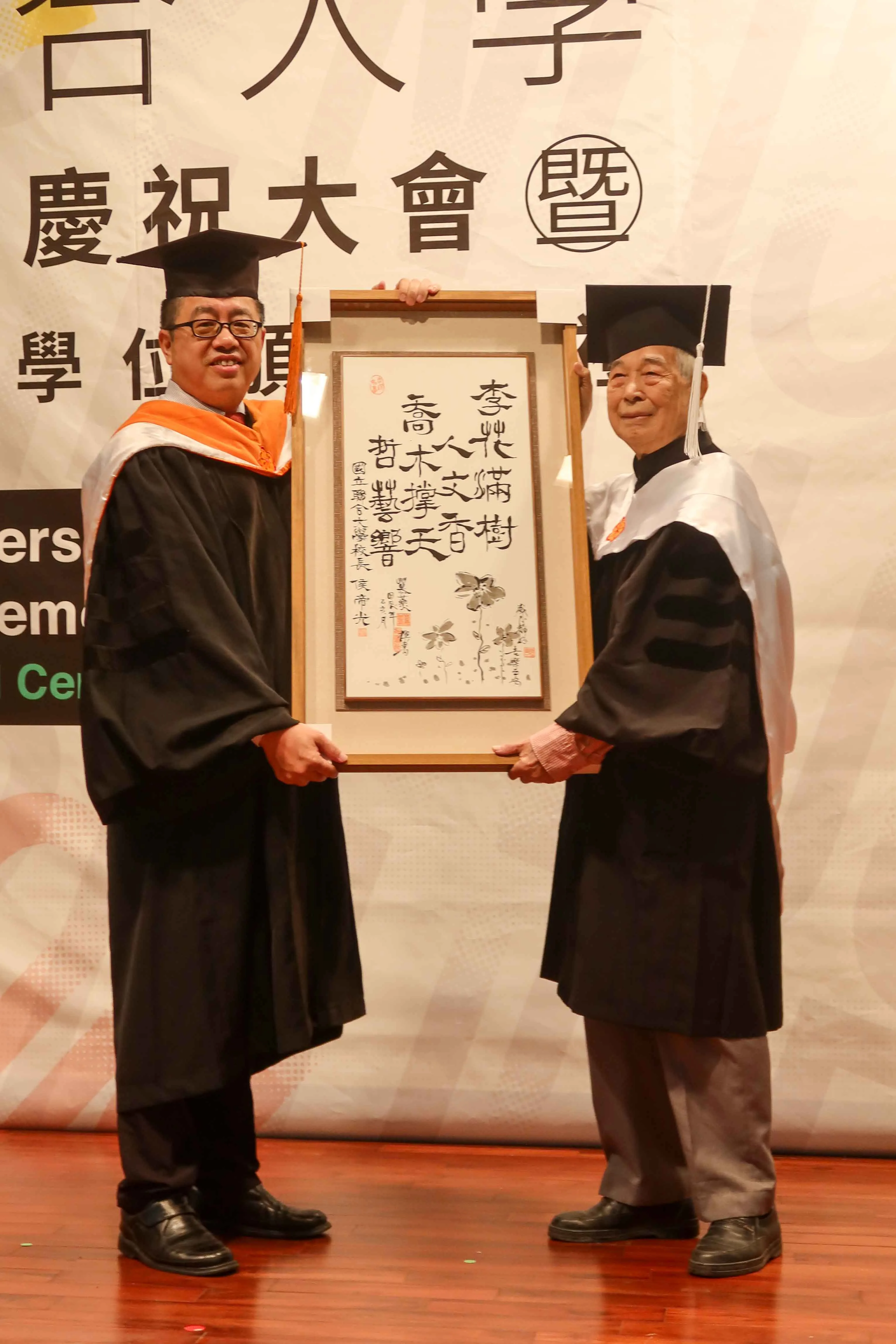 聯大校長侯帝光致贈「李花滿樹人文香,喬木撐天哲藝響」書法鏡屏給李喬。何來美攝