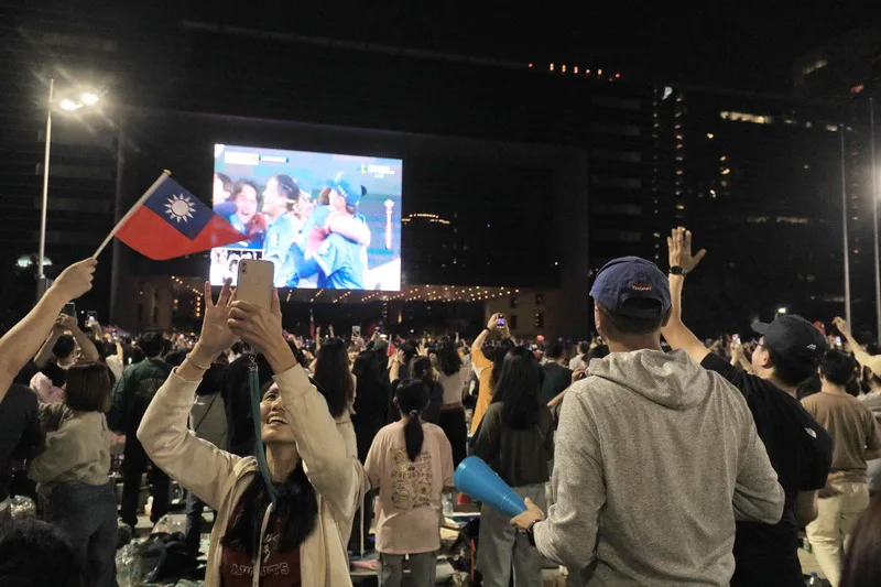 台中市政府前廣場的直播派對現場民眾嗨翻，眾人興奮歡呼吶喊，也有人拿出中華民國國旗熱情揮舞。中央社