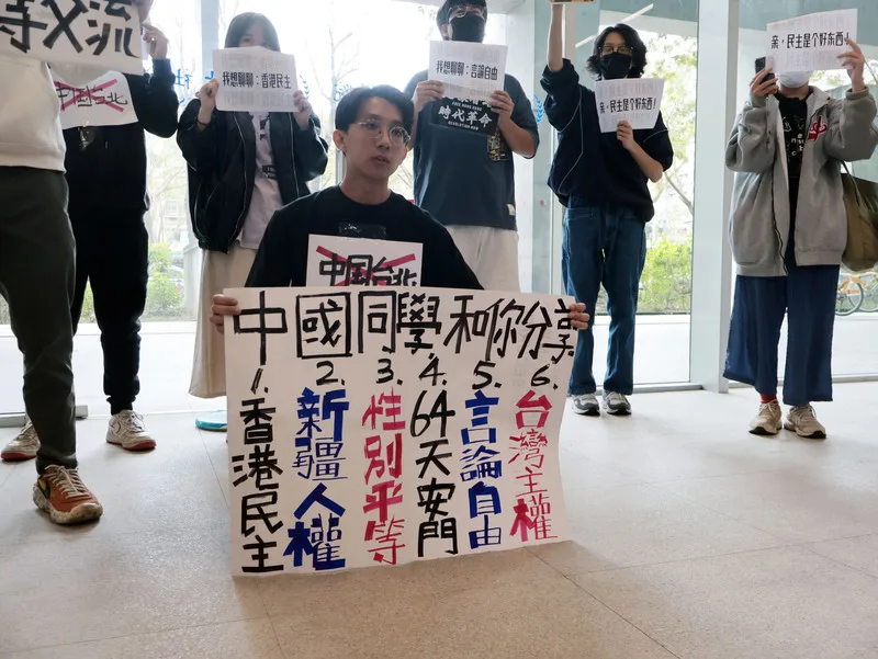 陸生訪台，台灣大學學生集結社會科學院一樓，手持看板。中央社