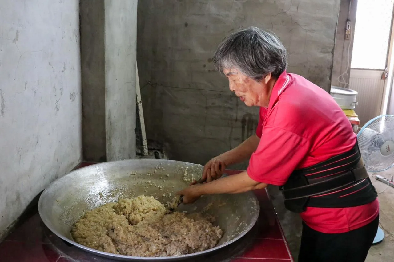 劉蘭英用大鑊頭炒甜糯米飯，必須炒到糯飯與糖均勻始完成。何來美攝