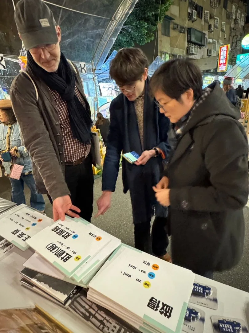 來自法國的遊客，也在攤位上認真研究客語拼音。客傳會公服部