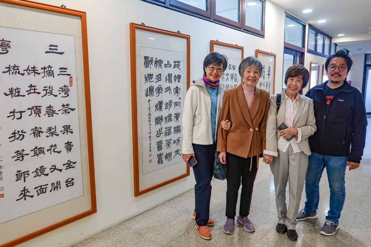 賴丹桂、張簡曉芸母女（左二、左一）、賴明珠（右二）及姪兒（右一）到聯大國鼎書館七樓，欣賞父親、祖父賴江質的苗栗縣十八鄉鎮市頌詩作。何來美攝