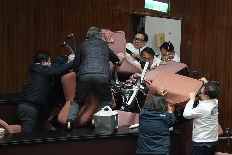 綠營19日打破議場窗戶闖入占主席台。藍委20日攻上主席台，欲將趴在主席台上的民進黨立委帶離現場，雙方攻防拉鋸戰。中央社