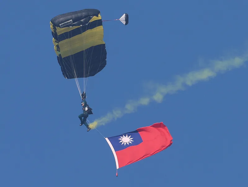 神龍小組實施高難度的3人扇形、Y形疊傘，同時在空中展開中華民國國旗（圖），展現精湛操傘技術。中央社