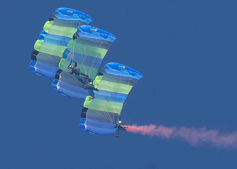 神龍小組20日搭乘C-130H運輸機自高空1萬呎高空一躍而下，實施高難度的3人扇形、Y形疊傘（圖），展現精湛操傘技術。中央社