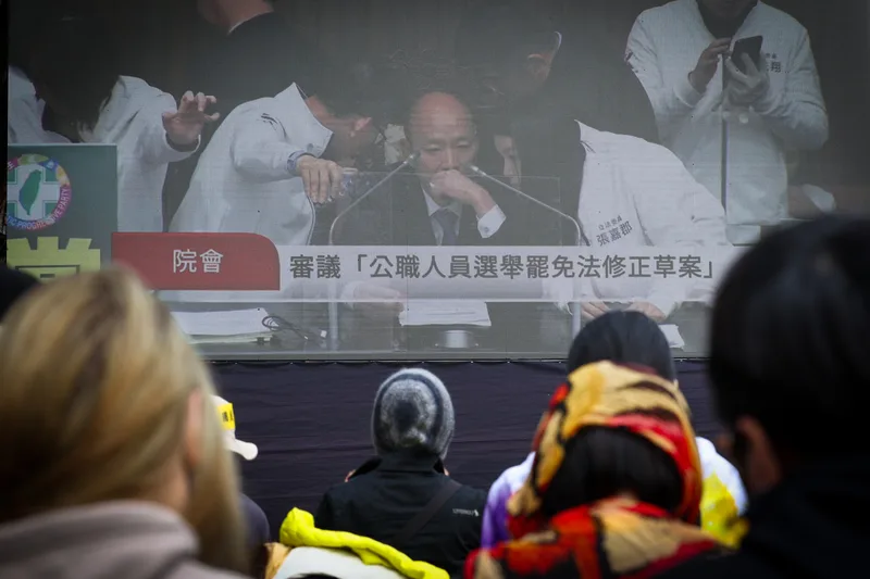 立法院會20日處理選罷法等修正案,公民團體在院外訴求退回法案,與會群眾透過大螢幕關注議場審議進度。中央社