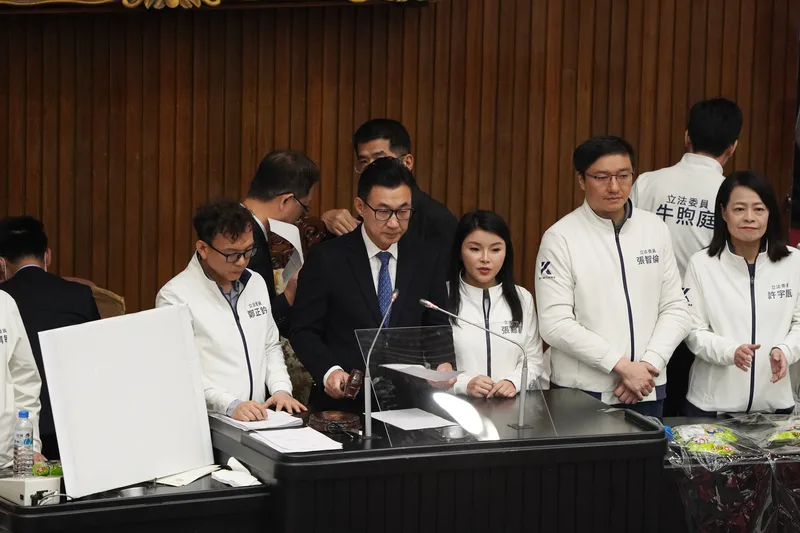 立法院副院長江啟臣(前左2)在多名國民黨籍立委包圍陪伴下,敲槌宣布選罷法三讀。中央社