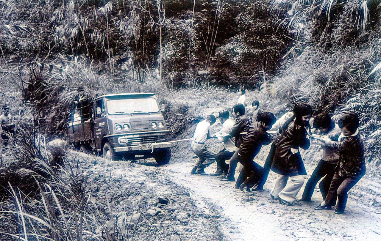產業道路的開闢帶動山村發展,也造成人口大量外流,圖為一輛貨車拋錨,老嫩大細幫忙拉車。陳雲錦攝