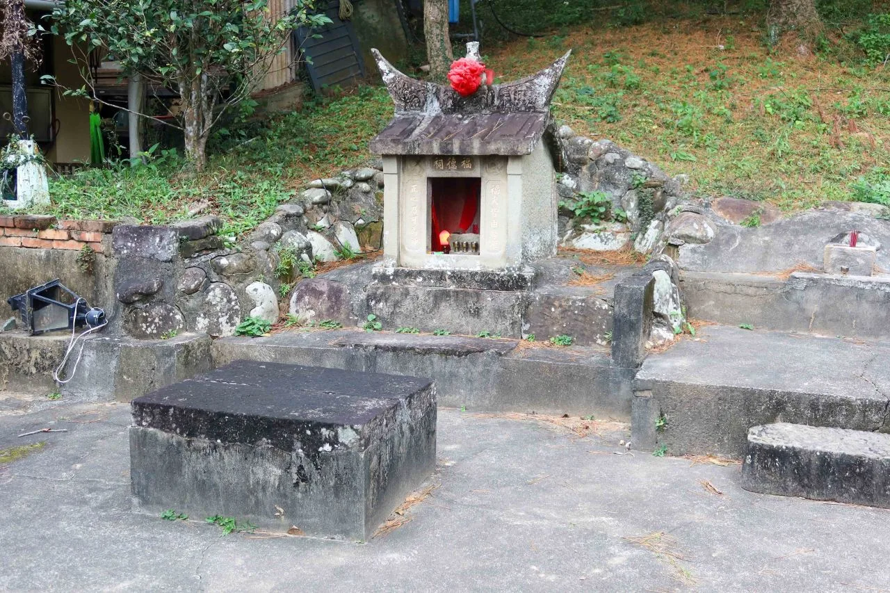 這座建於清同治7年（1868）的貓閣社石造土地公廟，位於頭屋鄉曲洞村墨硯山的山坡下。何來美攝