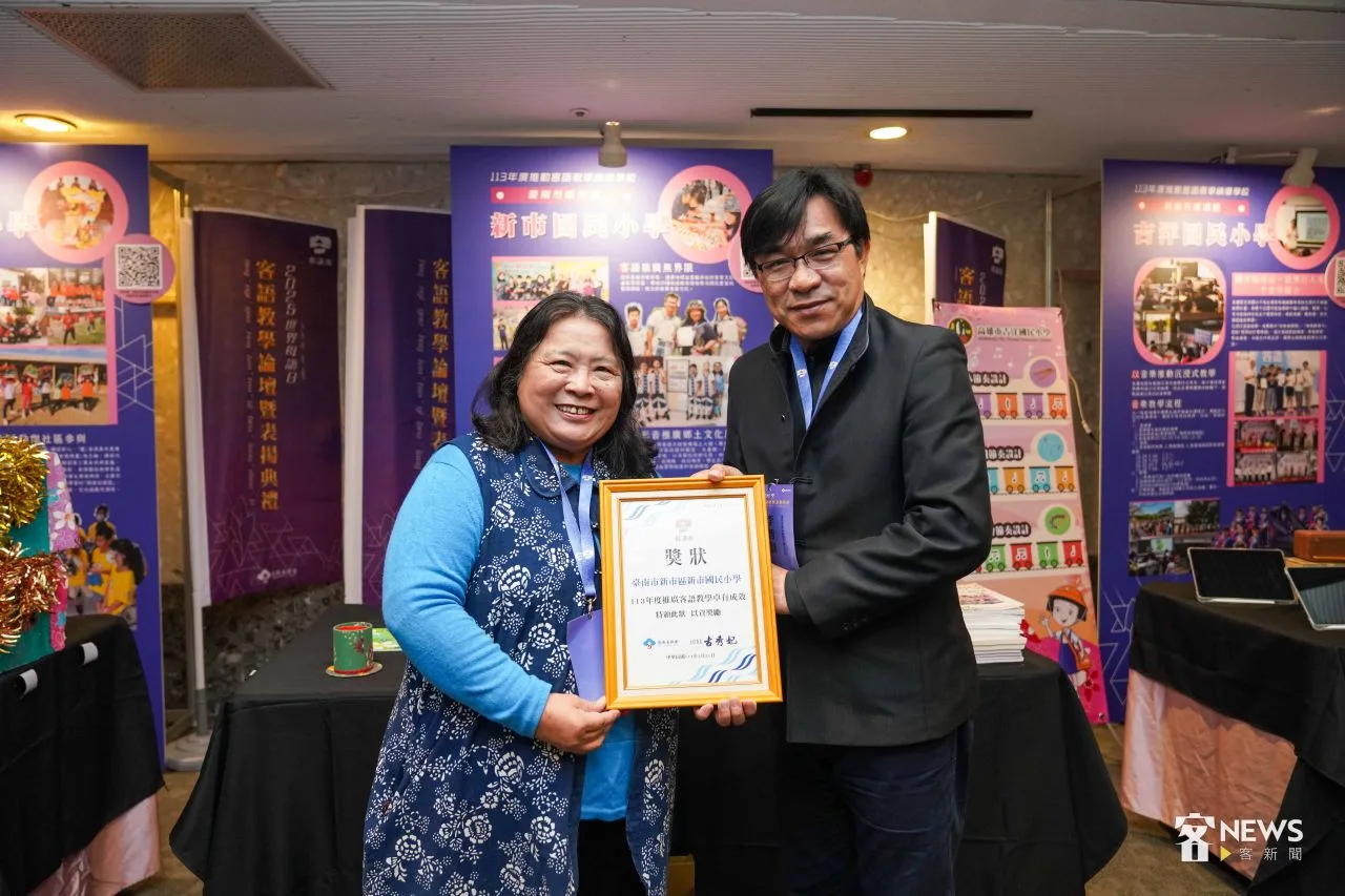 台南市新市國小校長李智賢、老師謝明麟拿著客委會頒發的獎狀合影。李台源攝