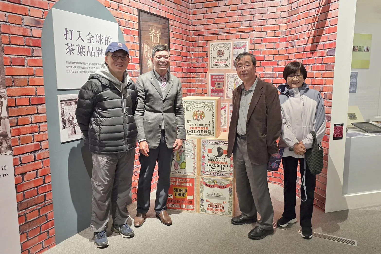 日本菊池秀明教授（右2）、臺大羅士傑副教授（左1）與何金樑主任（左2）一同在「拼．靚」特展中「茶產業」與「茶金」場景前留下合影。客發中心提供