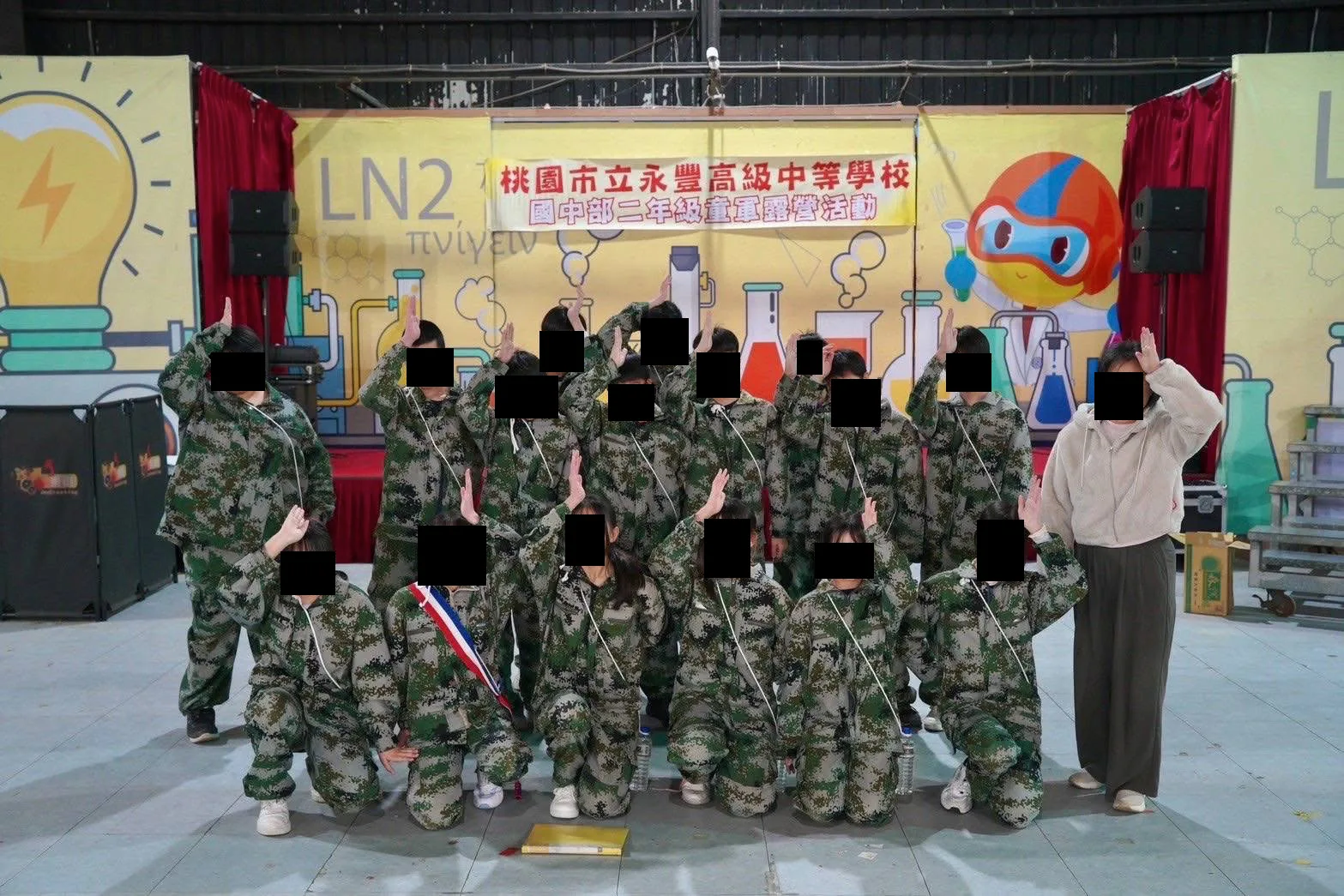 桃園市永豐高中國中部公民訓練穿中國解放軍迷彩服、中國少年先鋒隊手勢敬禮。魏筠提供
