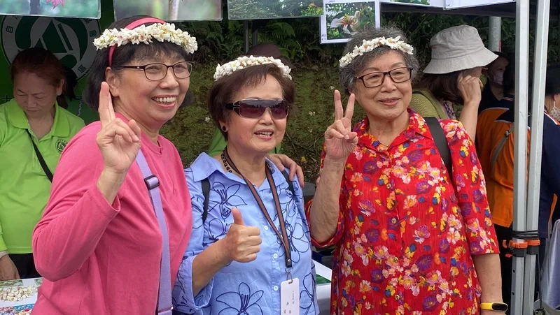 2025新北市客家桐花祭「青春桐樂會」19日在土城區熱鬧登場，吸引許多民眾上山參與，開心戴著桐花花環合影。中央社