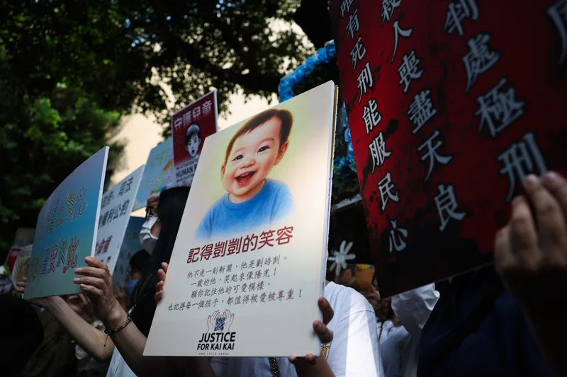 台北地院國民法官法庭13日判處劉彩萱無期徒刑、劉若琳18年徒刑，圖為場外民眾高舉聲援男童看板。中央社