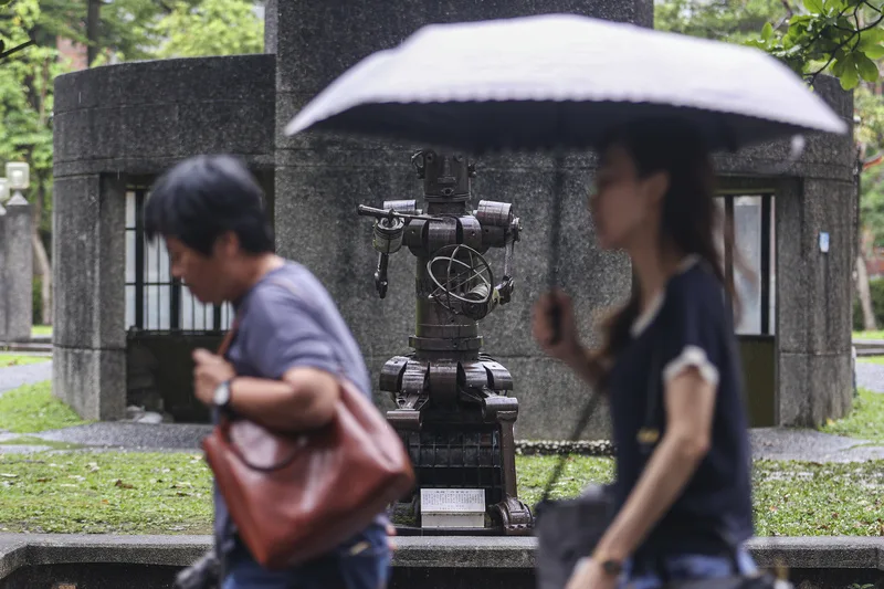 26日北台灣雲量多，仍有局部短暫雨，29日下一波鋒面南下，各地慎防劇烈天氣。圖為台北市大安區民眾撐傘擋雨。中央社