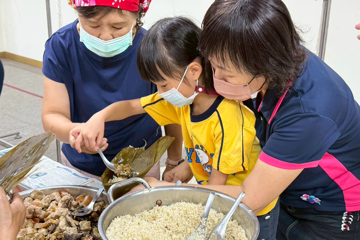 火焰蟲非營利幼兒園今（29）日上午在客家文物館舉辦包粽活動。高雄市客委會提供