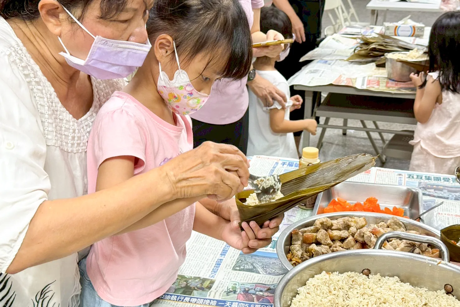 火焰蟲非營利幼兒園今（29）日上午在客家文物館舉辦包粽活動。高雄市客委會提供