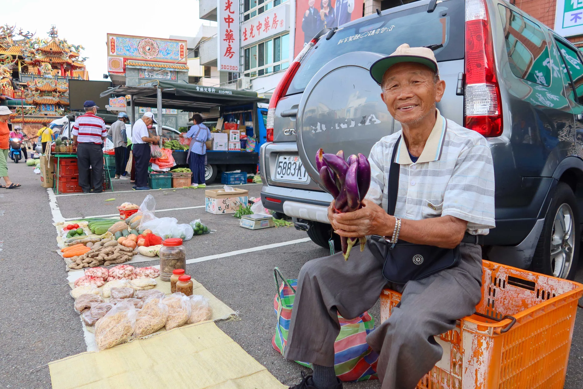 84歲徐仁勇自種蔬果到玉清宮前廣場加減賣，清晨6點半已賣到只剰一把笳子。何來美攝