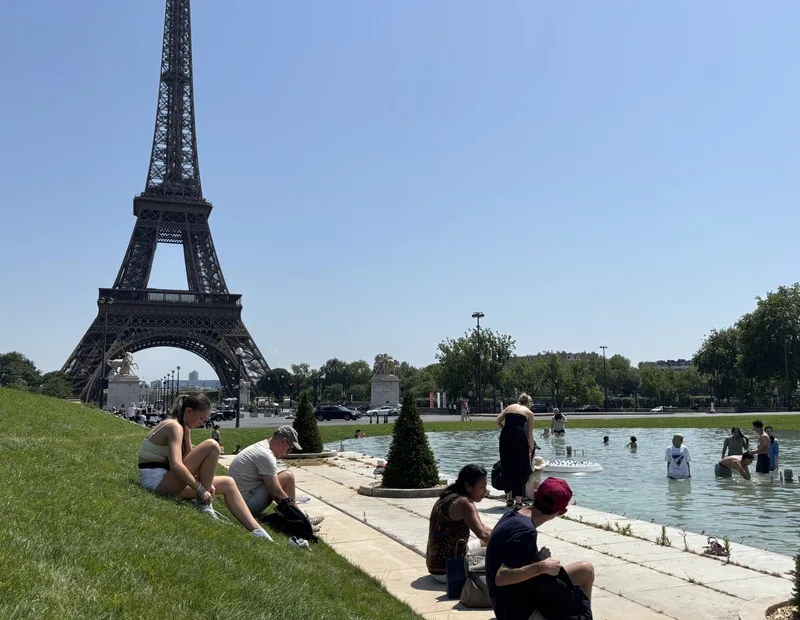 熱浪肆虐歐洲，巴黎艾菲爾鐵塔鐵塔頂層關閉，塔前的大型水池成了好去處，讓民眾盡情消暑，既降溫又有美景。中央社