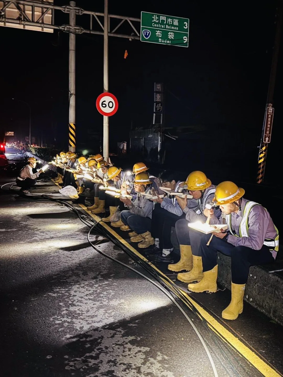 南台灣停電嚴重,台電人員利用空檔蹲坐路邊一排吃便當。翻攝自 台電電力粉絲團 臉書