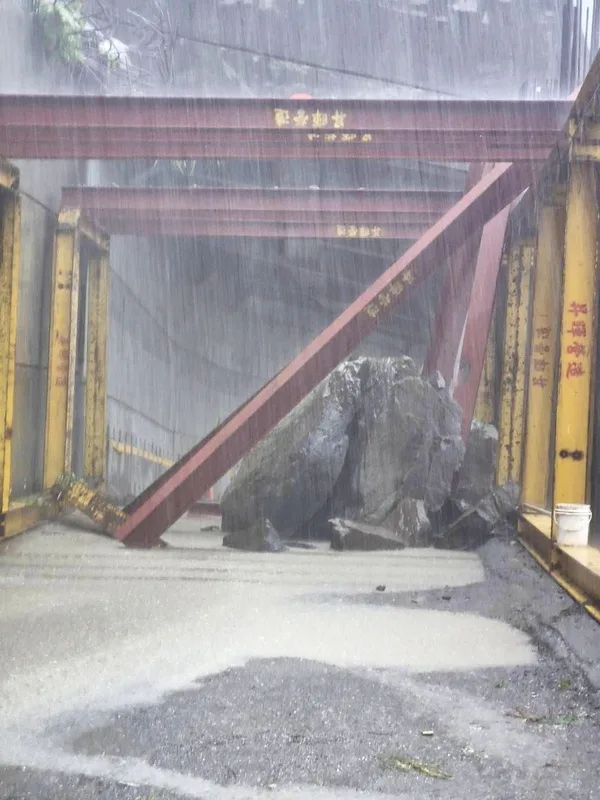 嘉義縣山區雨勢不斷,阿里山鄉達邦公路石棹至達邦路段約28K處施作明隧道工程區域,9日下午發生落石,巨大石塊阻斷道路、無法通行。嘉義縣政府提供