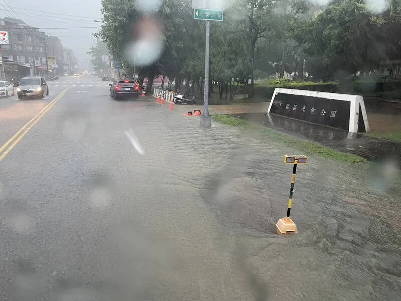 台中9日清晨持續降下大雷雨,沙鹿多處低窪地區出現積水現象,北勢東路的兒童公園前積水,被放置警示錐提醒用路人小心。民眾提供