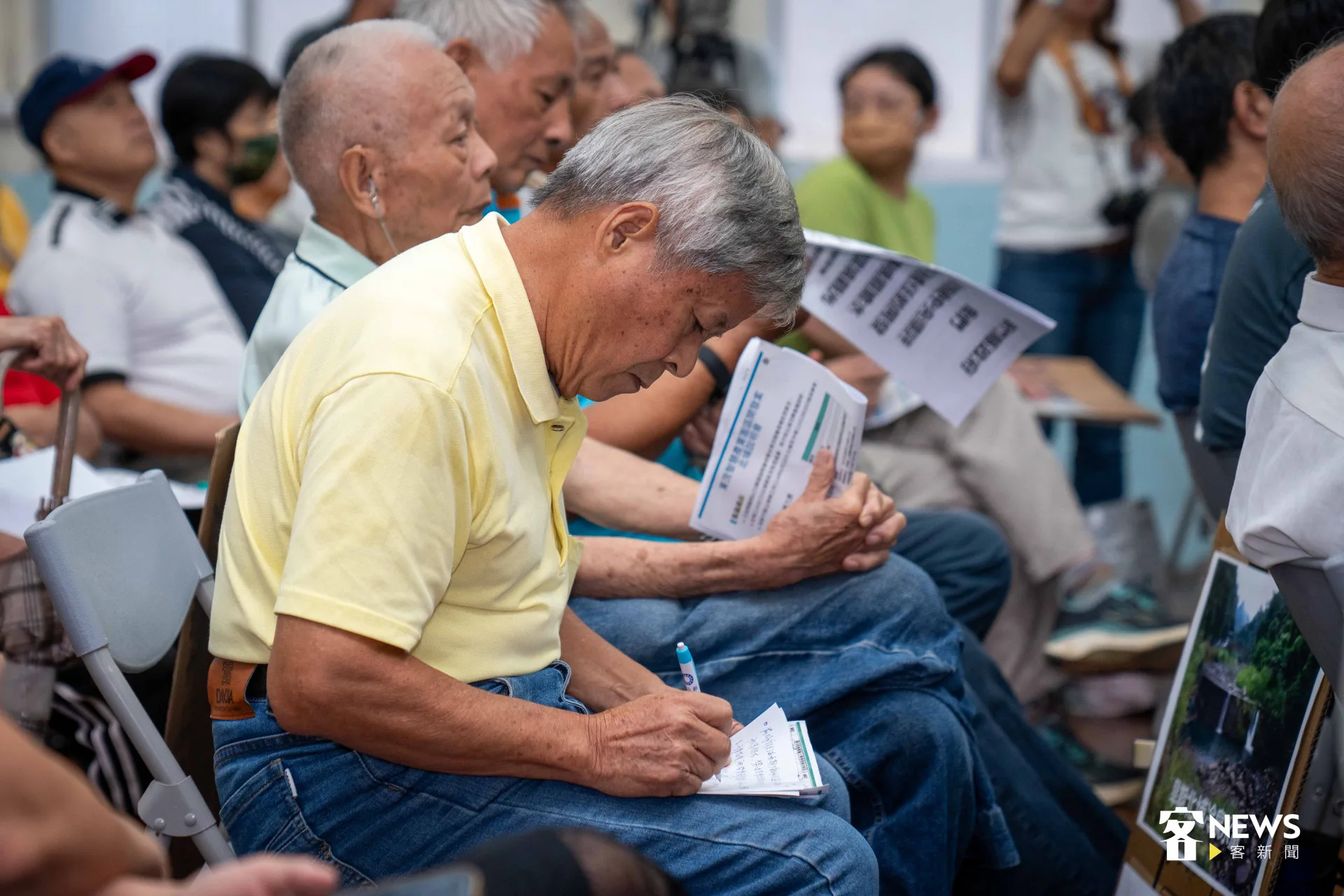 說明會現場,民眾低頭做筆記,寫下希望發言的內容。宋配遙攝