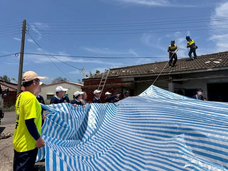 颱風丹娜絲重創嘉義沿海鄉鎮受,強風吹掀屋頂,慈濟志工提供100件帆布遮風擋雨,協助在屋頂鋪設帆布。慈濟嘉義聯絡處提供