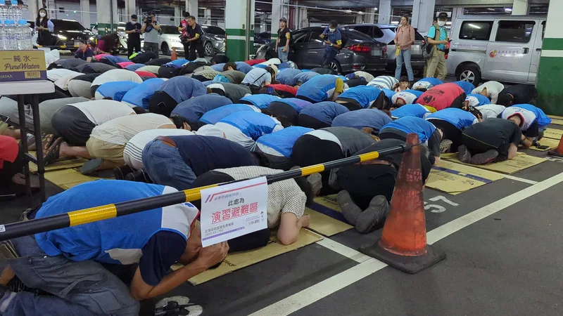 中部地區15日舉行城鎮韌性防空演習,台中市政府針對沙鹿區家樂福賣場演練,民眾採避難姿勢避難。中央社