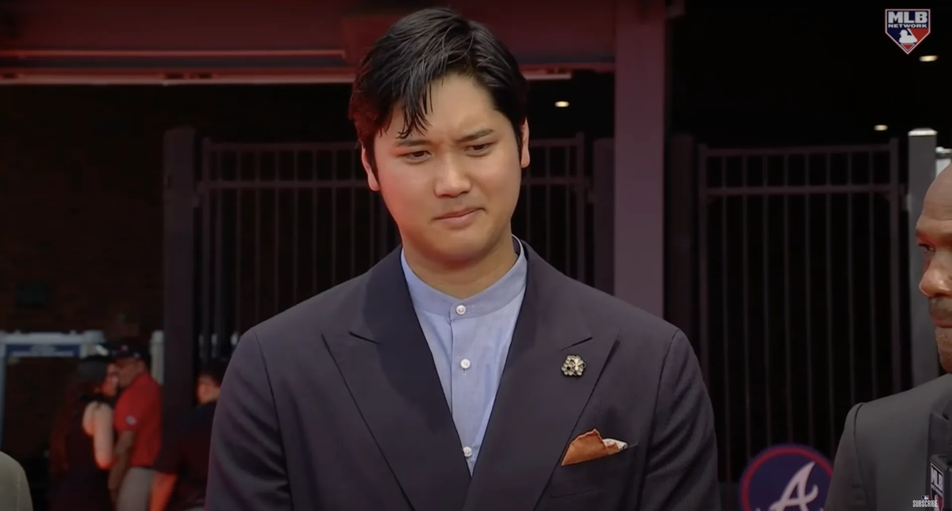 日本球星大谷翔平穿著深藍色無領西裝，搭配淺藍色襯衫。翻攝自 MLB YouTube