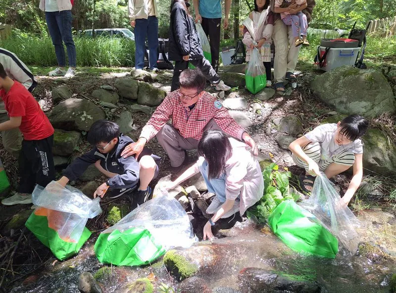 台灣櫻花鉤吻鮭生態中心舉辦各項推廣國寶魚保育工作，圖為小小巡守員放流體驗。雪霸國家公園管理處提供