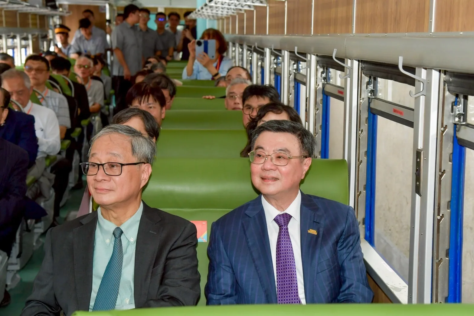 行政院長卓榮泰（右）與文化部長李遠（左）體驗搭乘藍皮客車。行政院提供
