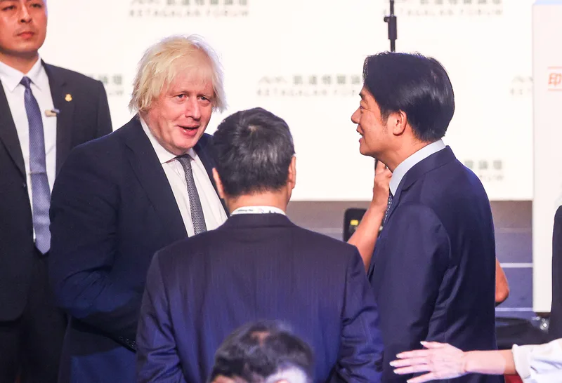 總統賴清德（右）5日上午在台北出席「凱達格蘭論壇：2025印太安全對話」開幕式，與英國前首相強生（Boris Johnson）（前左）在會中握手寒暄。中央社